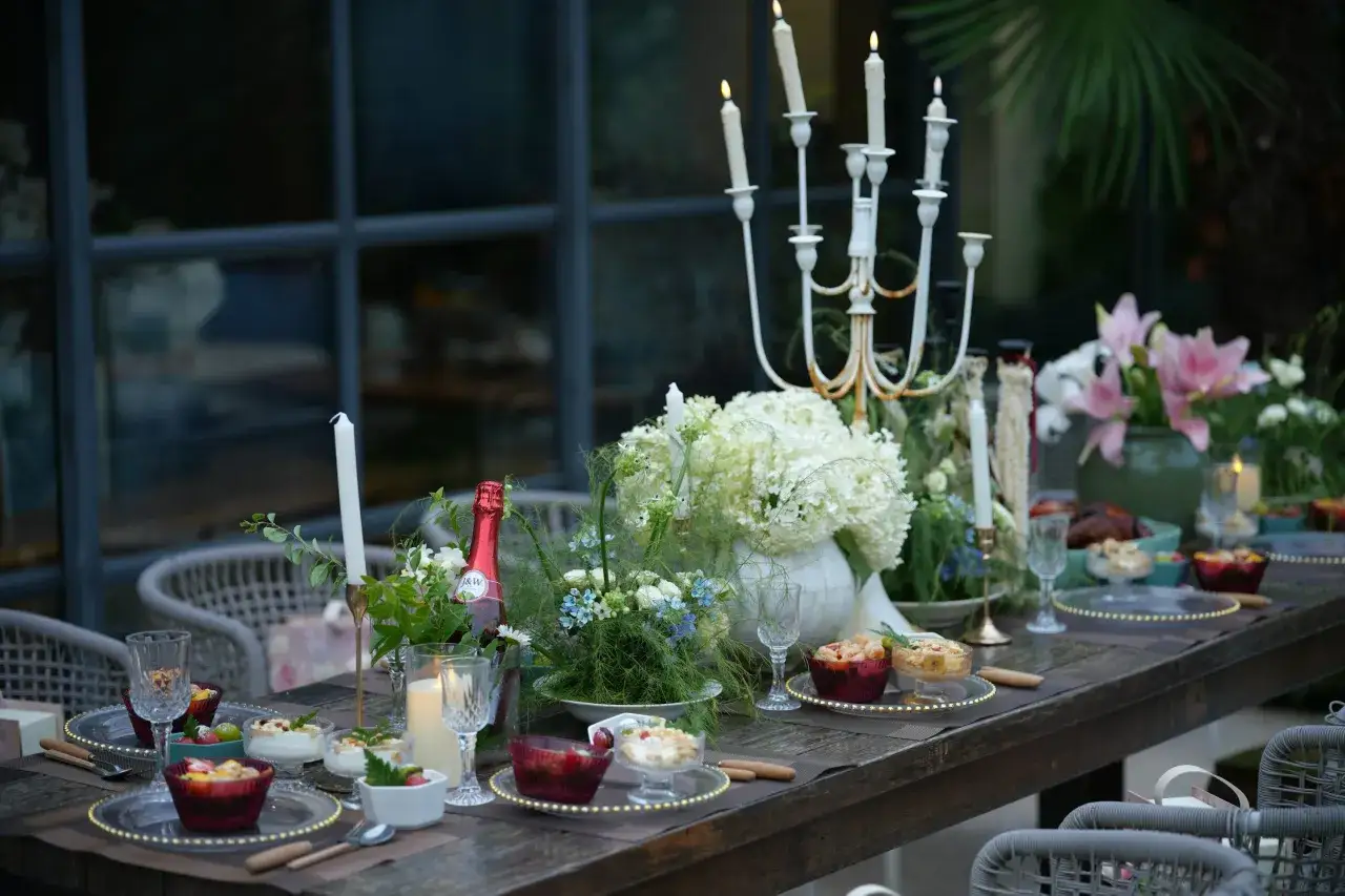 Elegante mesa puesta con velas y flores, lista para una cena romántica.
