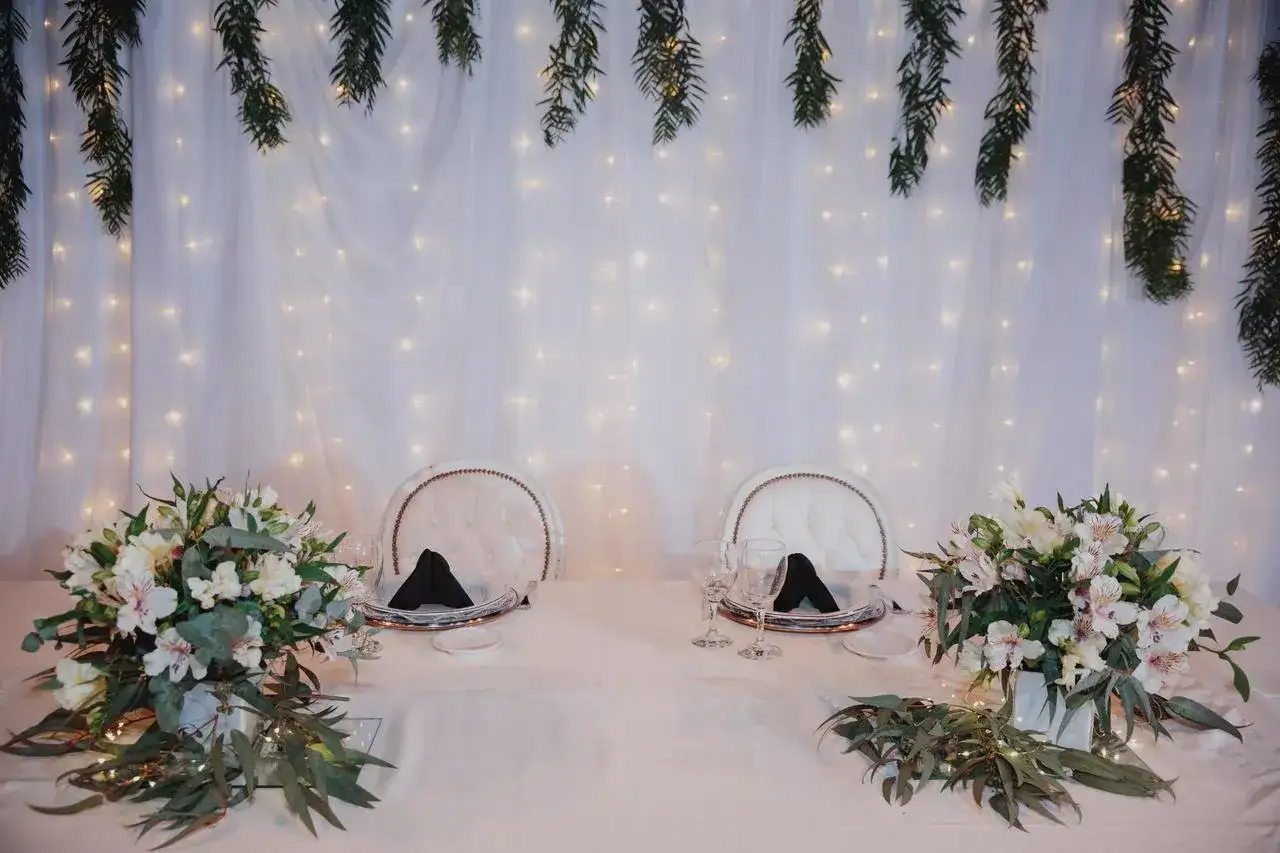 Mesa de bodas con flores y luces, ideal para planificar como hacer una boda económica y romántica.