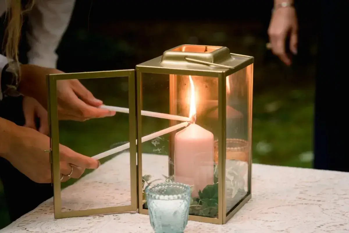 Manos encienden velas para una ceremonia de las velas.