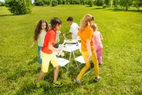 Niños jugando a las sillas musicales, uno de los 20 juegos para fiestas infantiles.