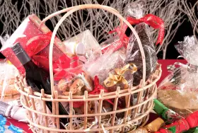 Canasta llena de dulces, galletas, una botella de vino y adornos navideños. ¡Perfecta para ideas para rifar!