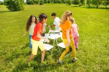 Niños jugando a las sillas musicales, uno de los 20 juegos para fiestas infantiles.