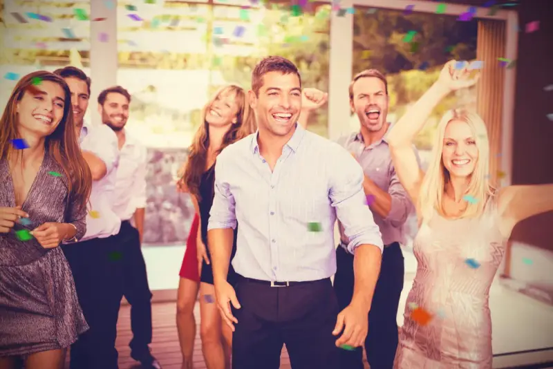 Grupo de amigos celebrando con confeti, listos para juegos de despedida de soltero.